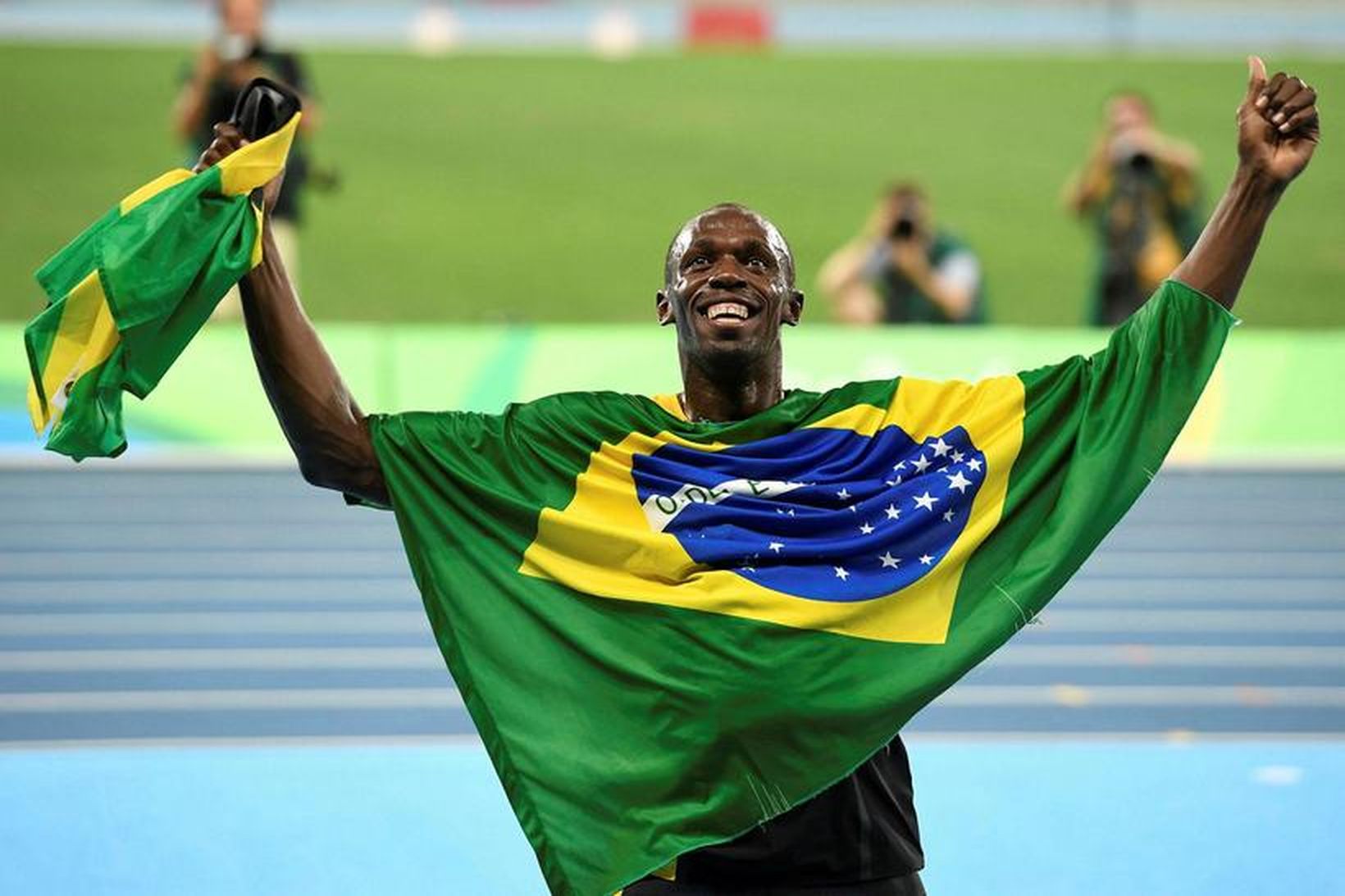 Usain Bolt sveipaði um sig brasilíska fánanum eftir fullkominn árangur …