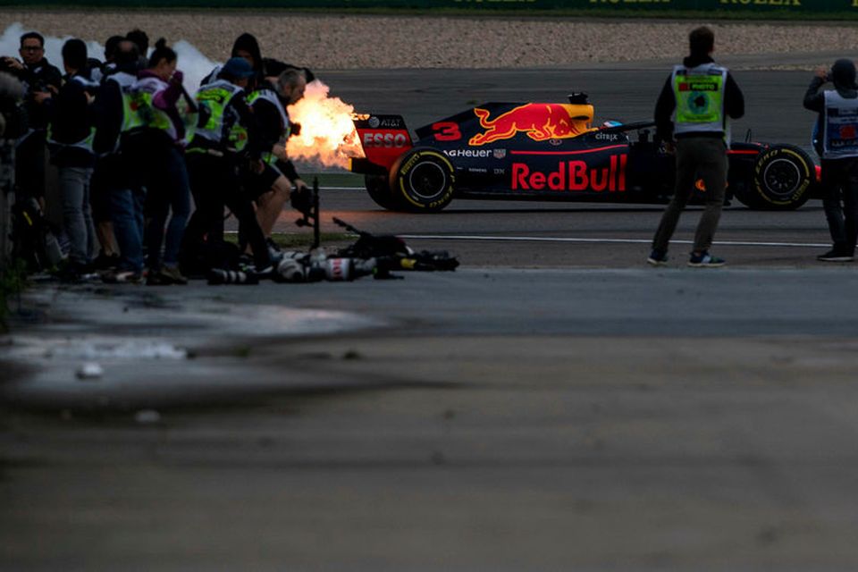 Eldur stígur upp af bíl Daniel Ricciardo á lokaæfingunni í Sjanghæ í morgun.