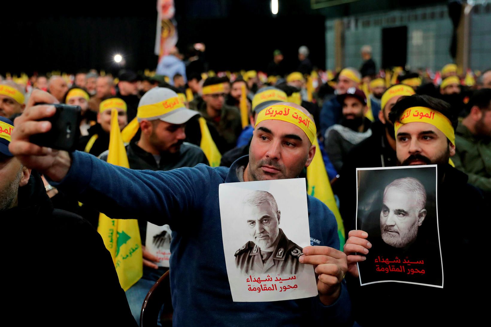 Fylgismenn Shiite Hezbollah-hreyfingarinnar taka sjálfsmynd með veggspjöldum af Qasem Soleimani.