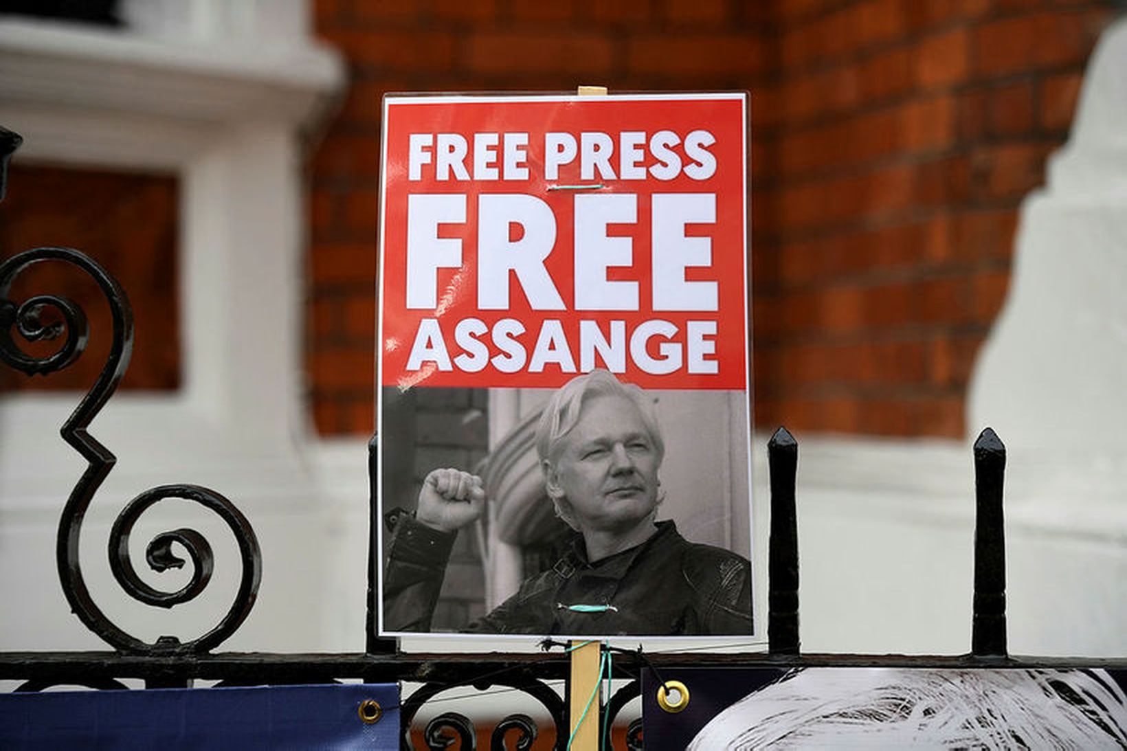 Stuðningsmaður Julian Assange heldur upp skilti til stuðnings honum við …