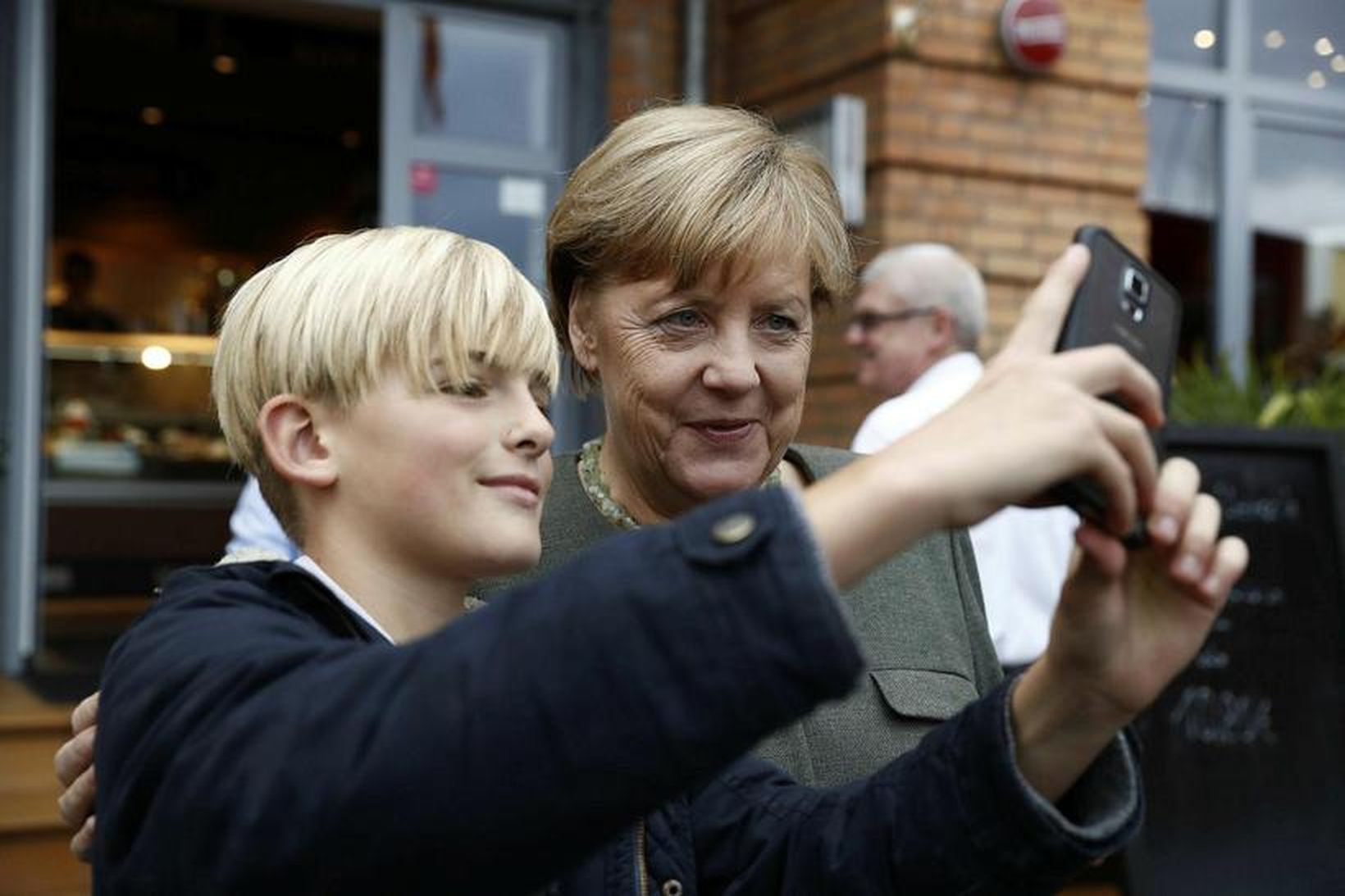 Angela Merkel Þýskalandskanslari stillir sér upp fyrir sjálfum með ungum …