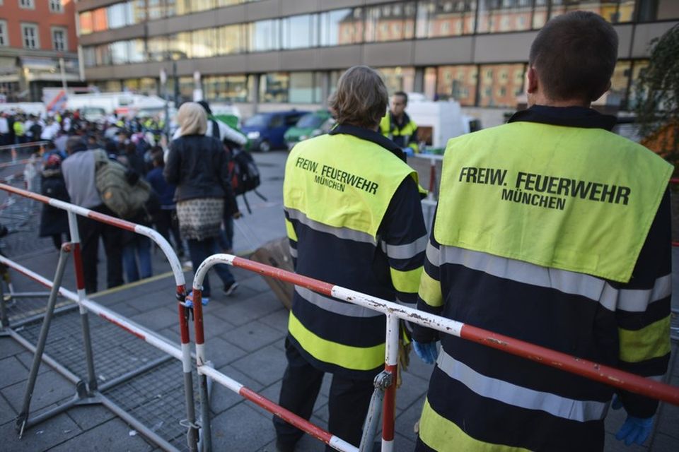 Slökkviliðsmenn fylgjast með komu fólksins í gær.