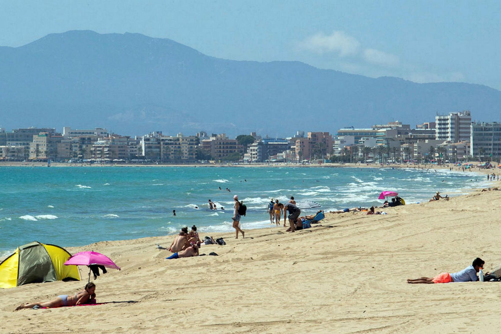 Gestir og heimamenn njóta sólarinnar á strönd Palma á Mallorca.