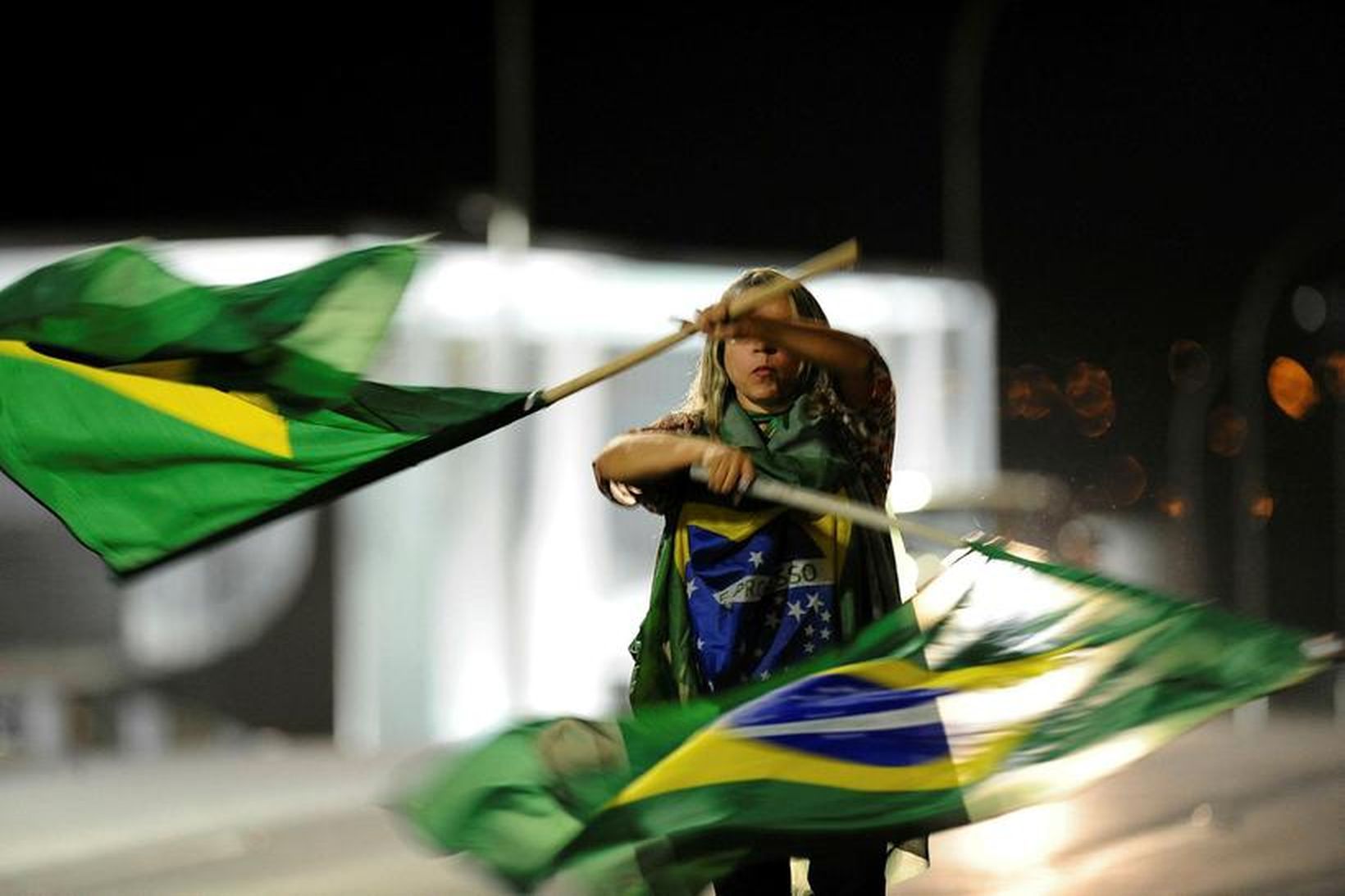 Andstæðingur Dilmu Rousseff forseta veifar brasilískum fánum fyrir utan þinghús …
