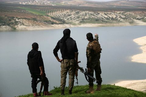 . Members of the armed Kurdish forces looking at lake Maydanki in Afrin, Syria.