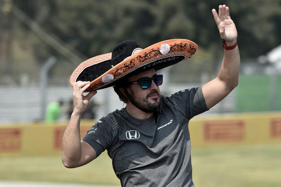 Fernando Alonso veifar áhorfendum á heiðurshring ökumanna fyrir kappaksturinn í Mexíkóborg.