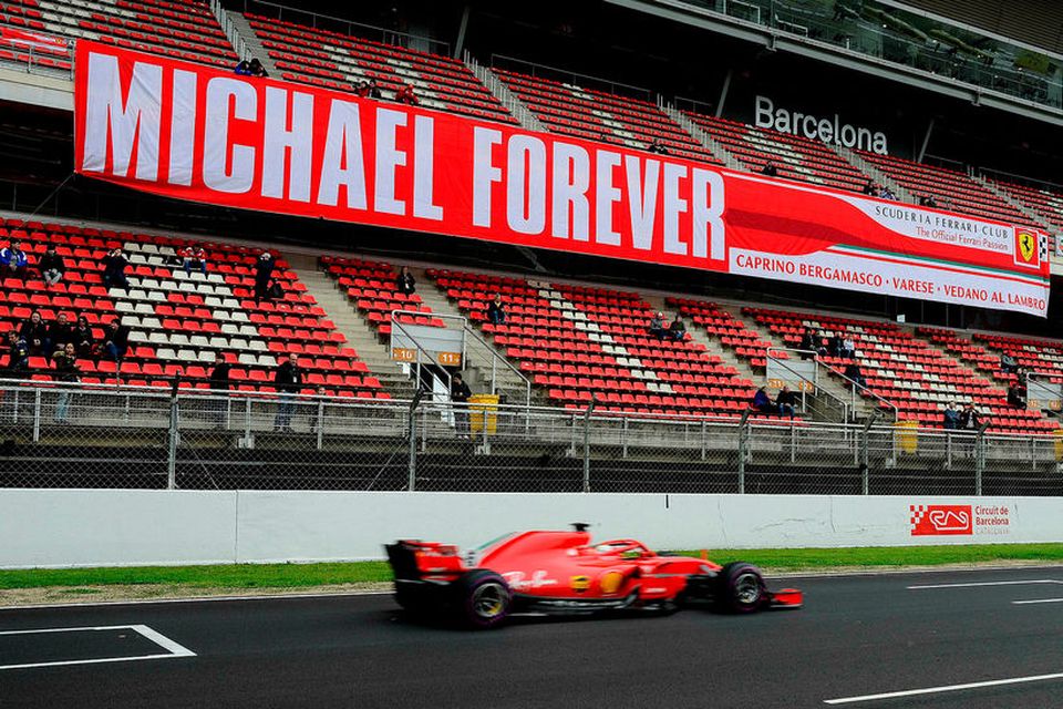 Sebastian Vettel í Barcelona í dag. Í stúkunni er minnst Michael Schumacher, sigursælasta ökumann Ferrari.