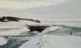 Áveituskurðurinn og flóðgáttin. Hvítá í hvarfi og í fjarska sjást sumarhús, skógur og Hestfjall í …