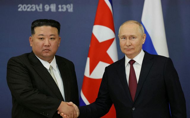 Kim Jong-un og Pútín takast í hendur.