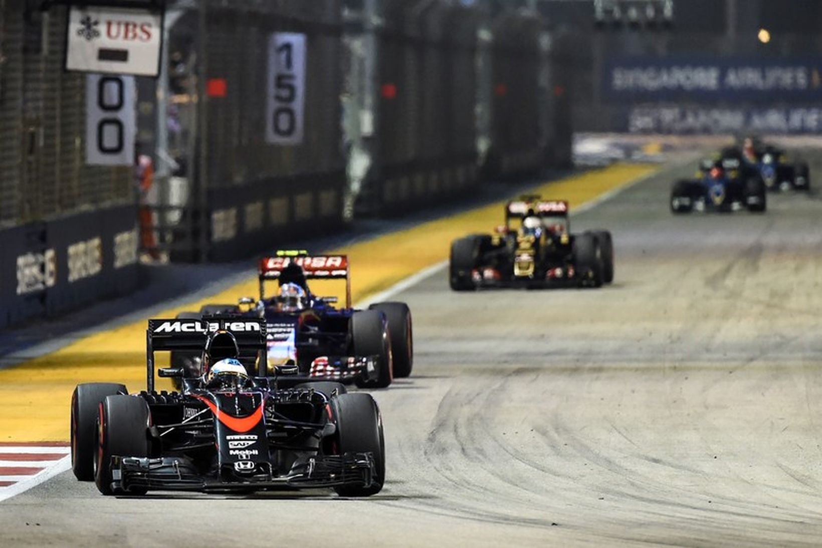 Fernando Alonso fremstur í fylkingu á McLarenbílnum í Singapúr í …
