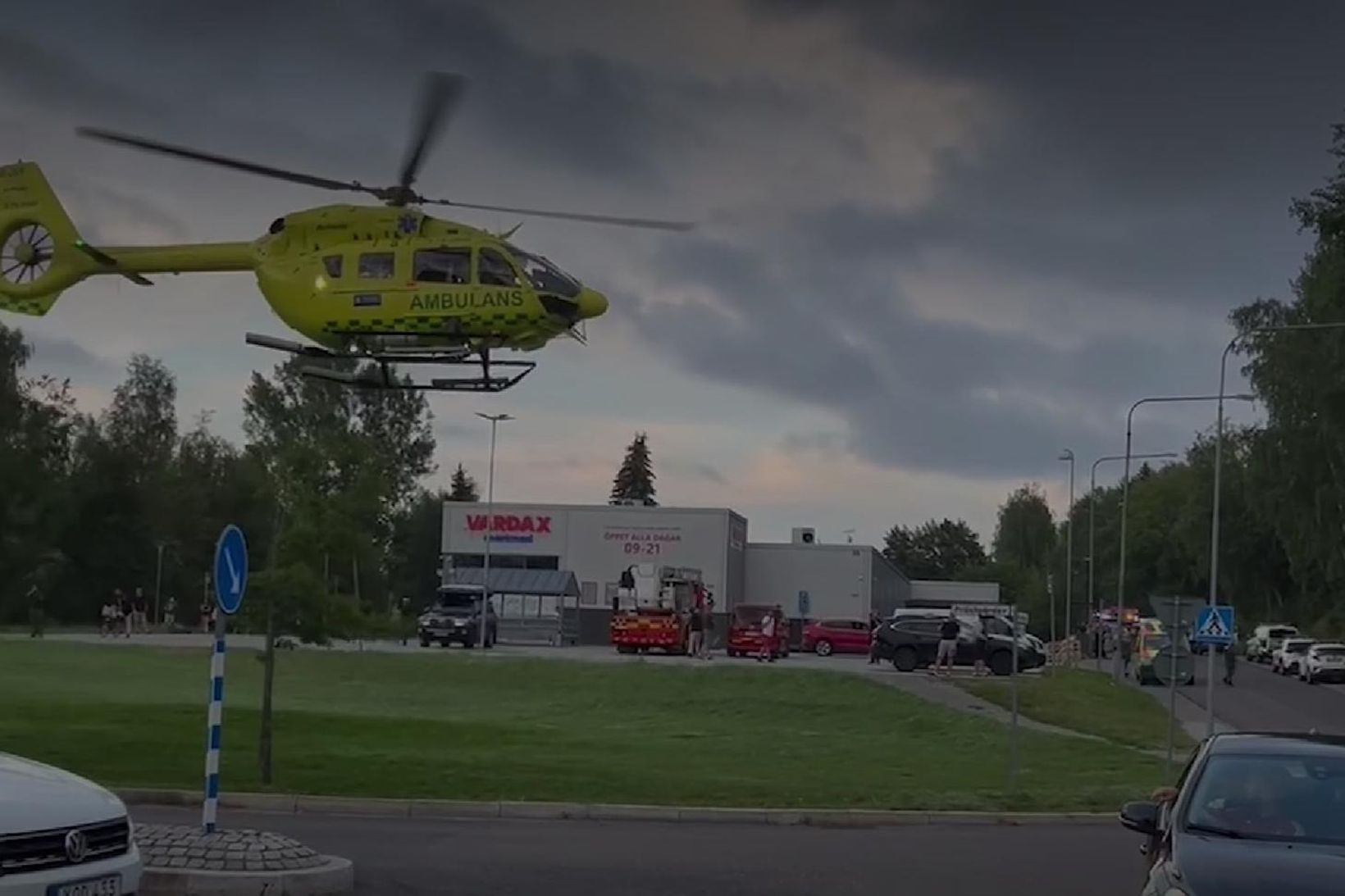 Sjúkraþyrla hefur sig til flugs við verslunina þar sem kona …