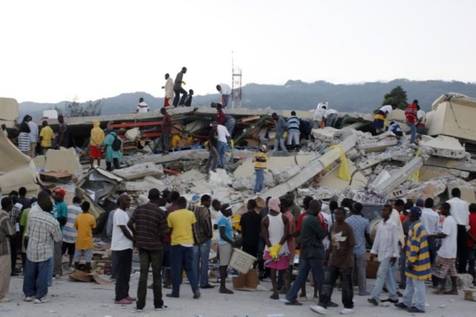 Borgarbúar í Port-au-Prince leita að fólki í rústum.