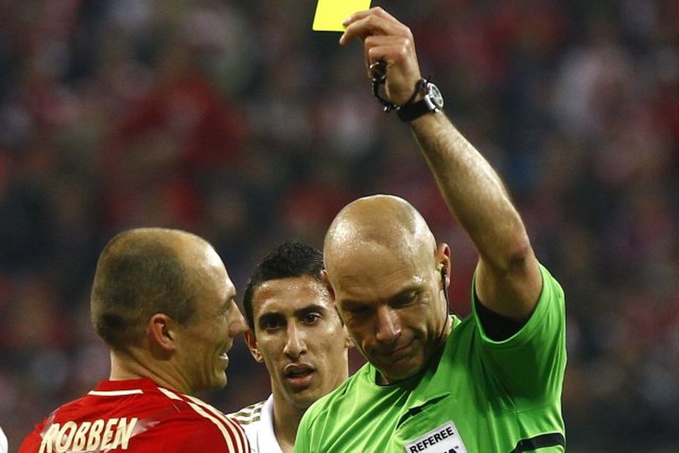 Howard Webb dómari sýnir Arjen Robben gula spjaldið.