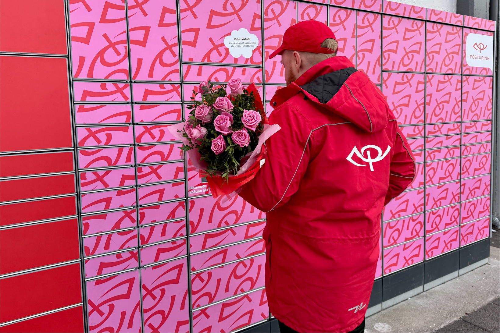 Starfsmaður Póstsins tilbúinn með blómvönd í Valentínusargjöf.