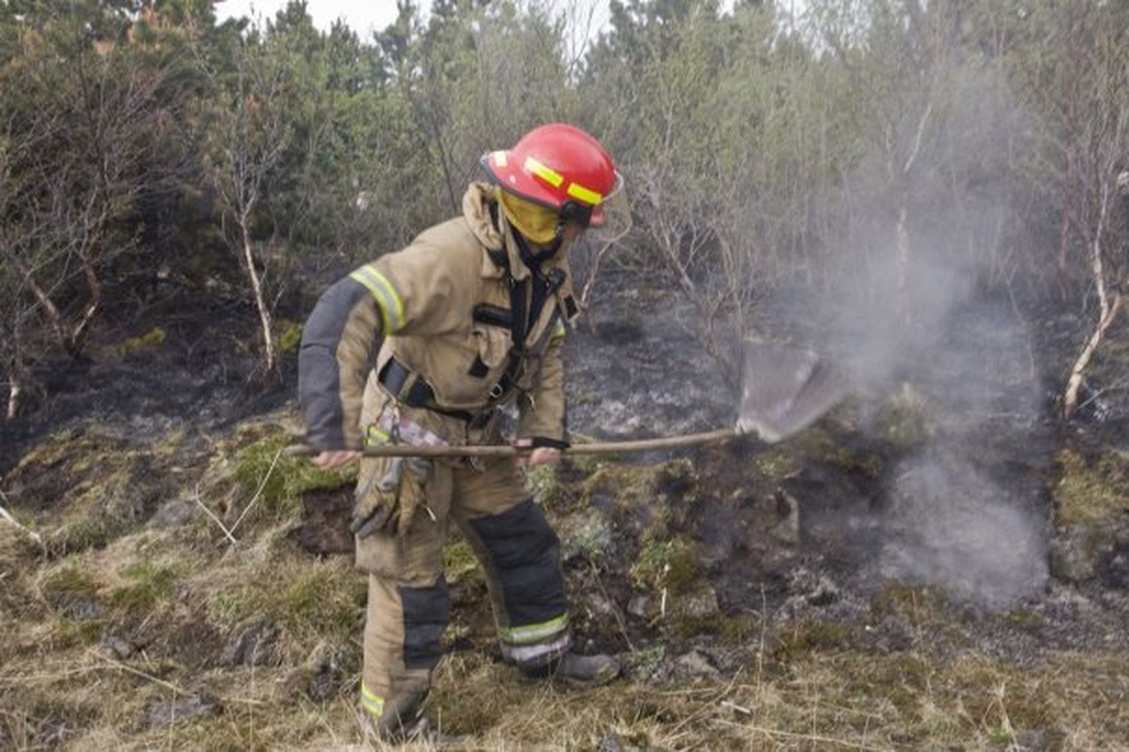 Slökkviliðsmaður að störfum í Elliðaárdal í dag.