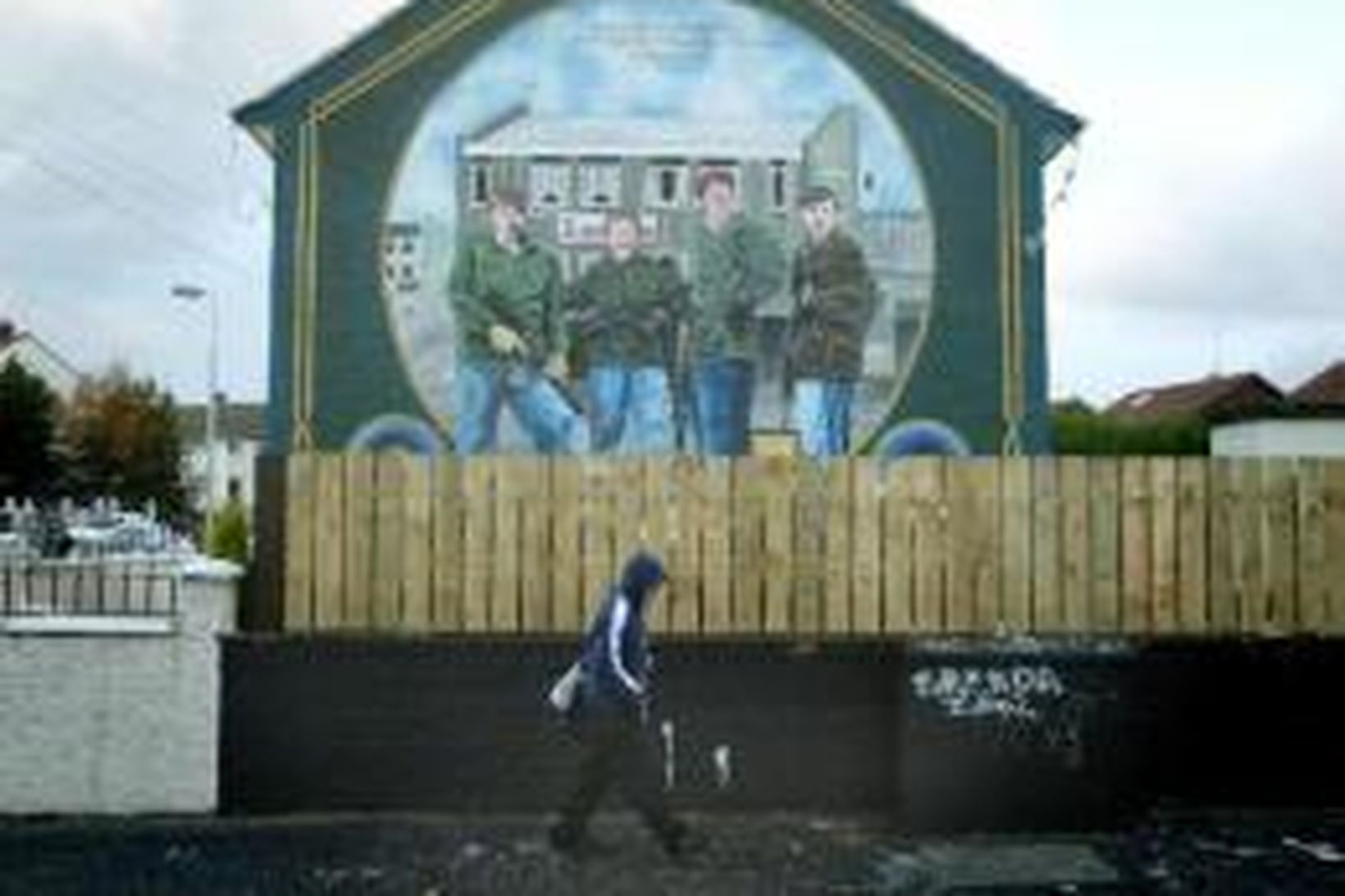 Veggmynd, sem táknar IRA-sveitir, á húsvegg í Belfast.