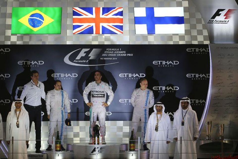Lewis Hamilton á efsta þrepi verðlaunapallsins í Abu Dhabi. Til vinstri er Felipe Massa hjá …