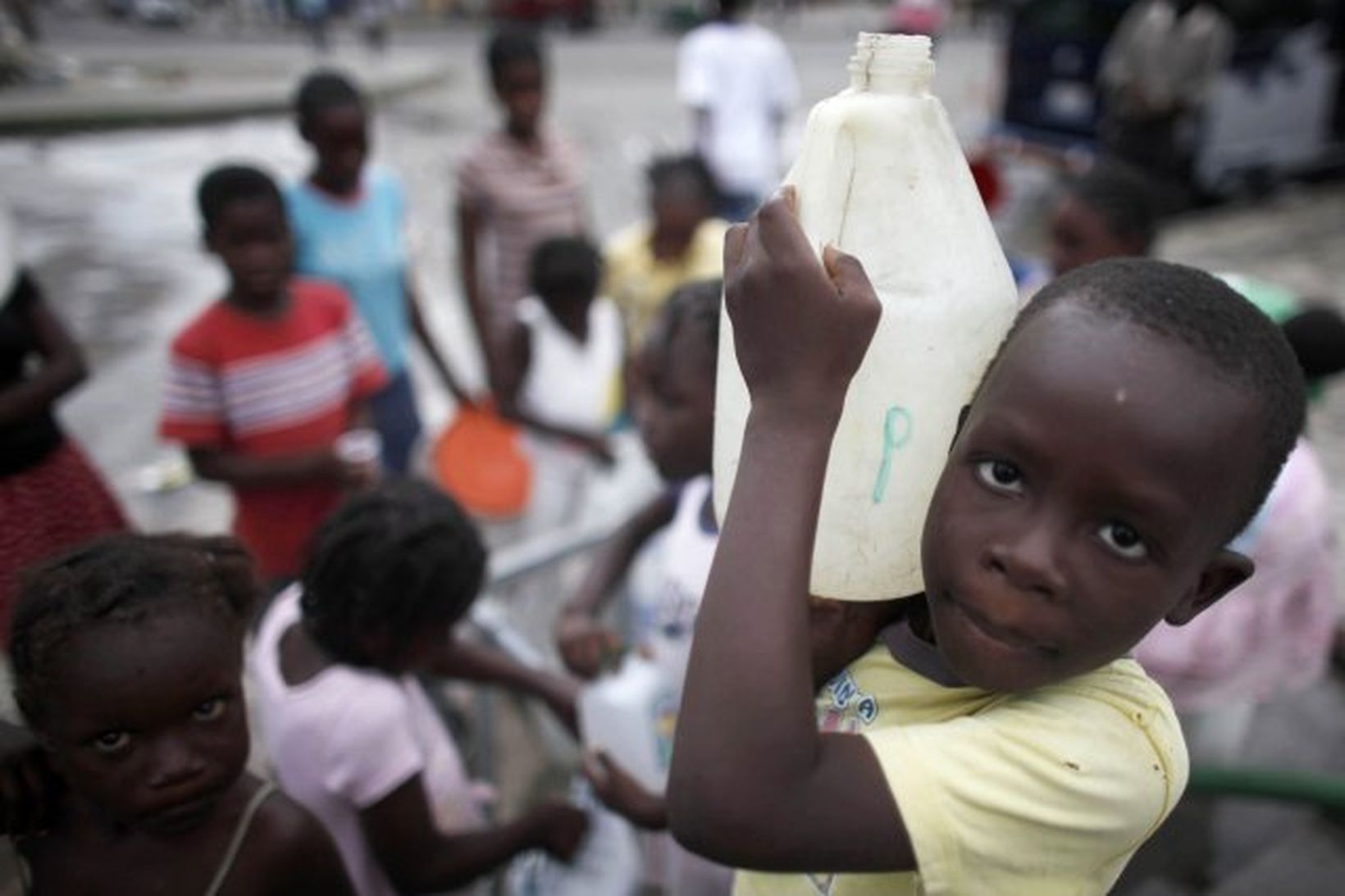 Börn bera vatn í Port-au-Prince höfuðborg Haítí í kjölfar jarðskjálftanna.