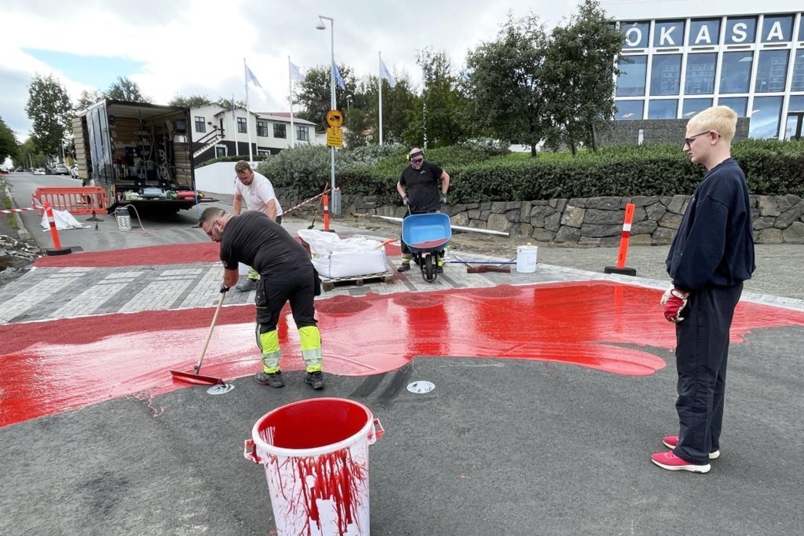 Rauðri málningu var hellt yfir malbikið og ofan í hana …