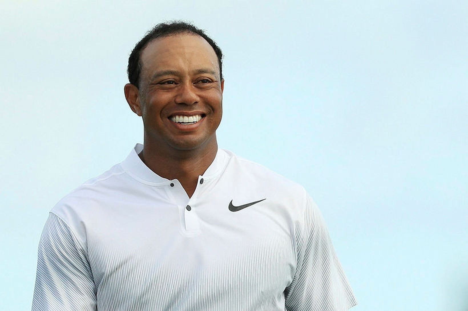 Tiger Woods var kátur á golfvellinum í dag.