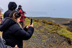 Er blaðamaður og ljósmyndari virtu Dyrhólaey fyrir sér flaug ferðamaður dróna úti yfir bjarginu.