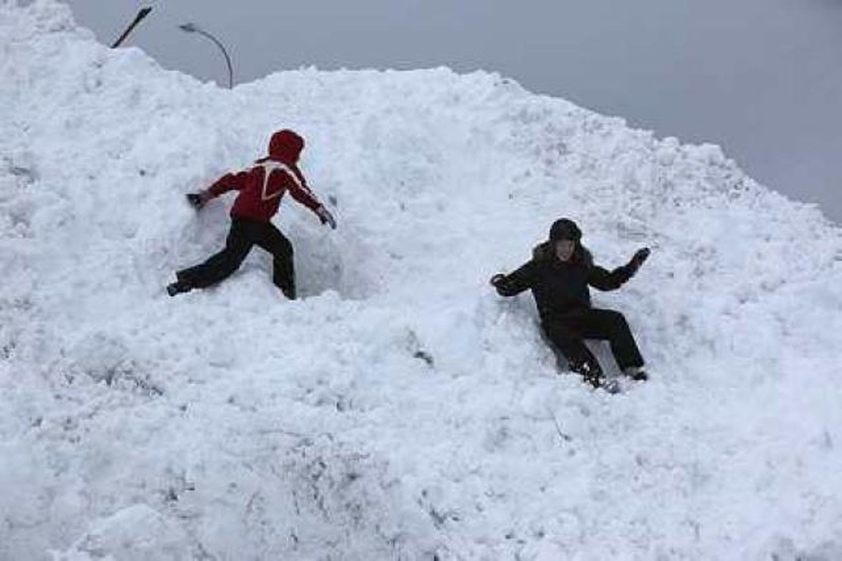 Börn léki sér í snjónum á Akureyri í gær.