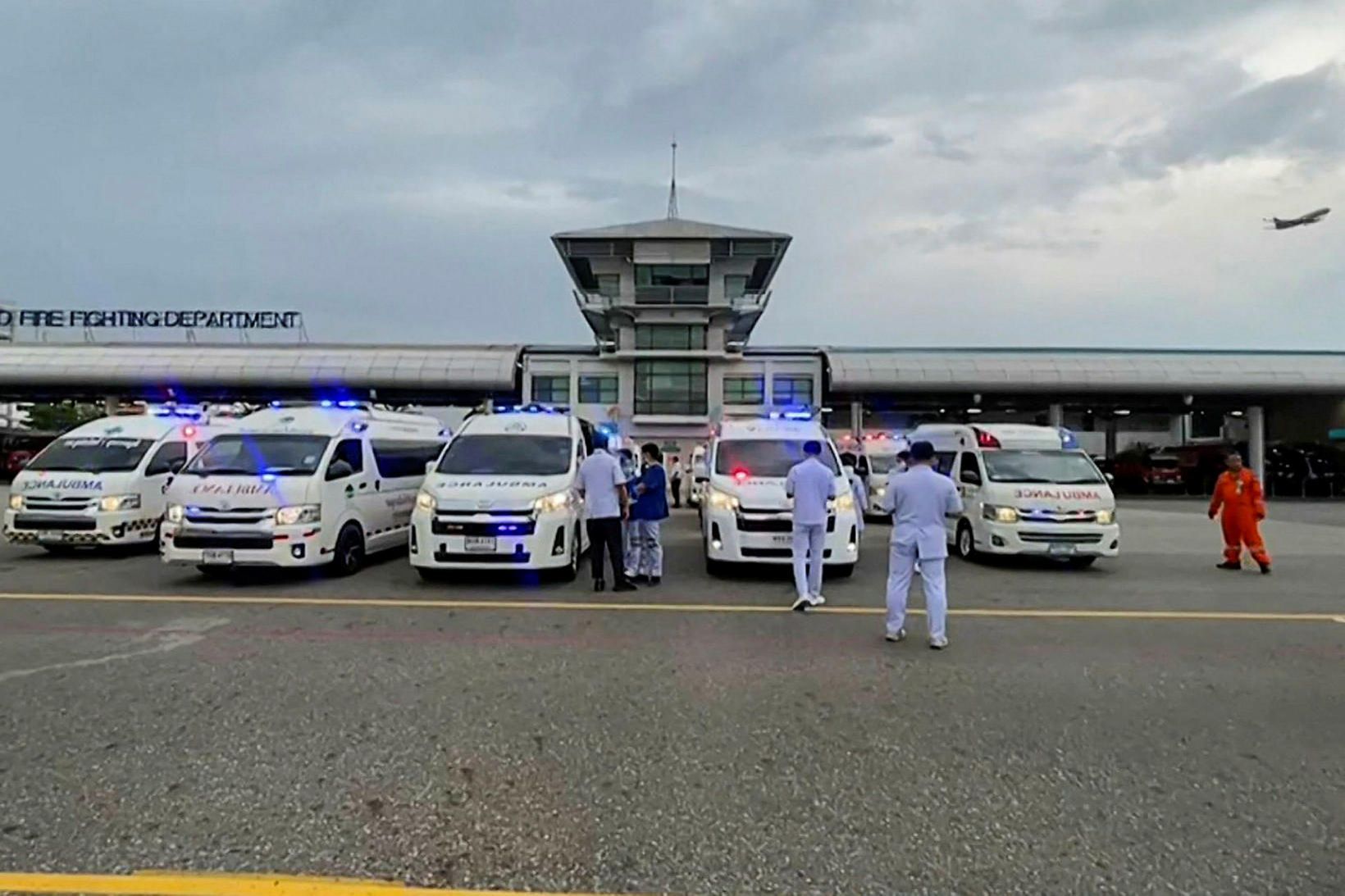 Sjúkraflutningamenn bíða eftir farþegaþotunni á flugvellinum í Bangkok.