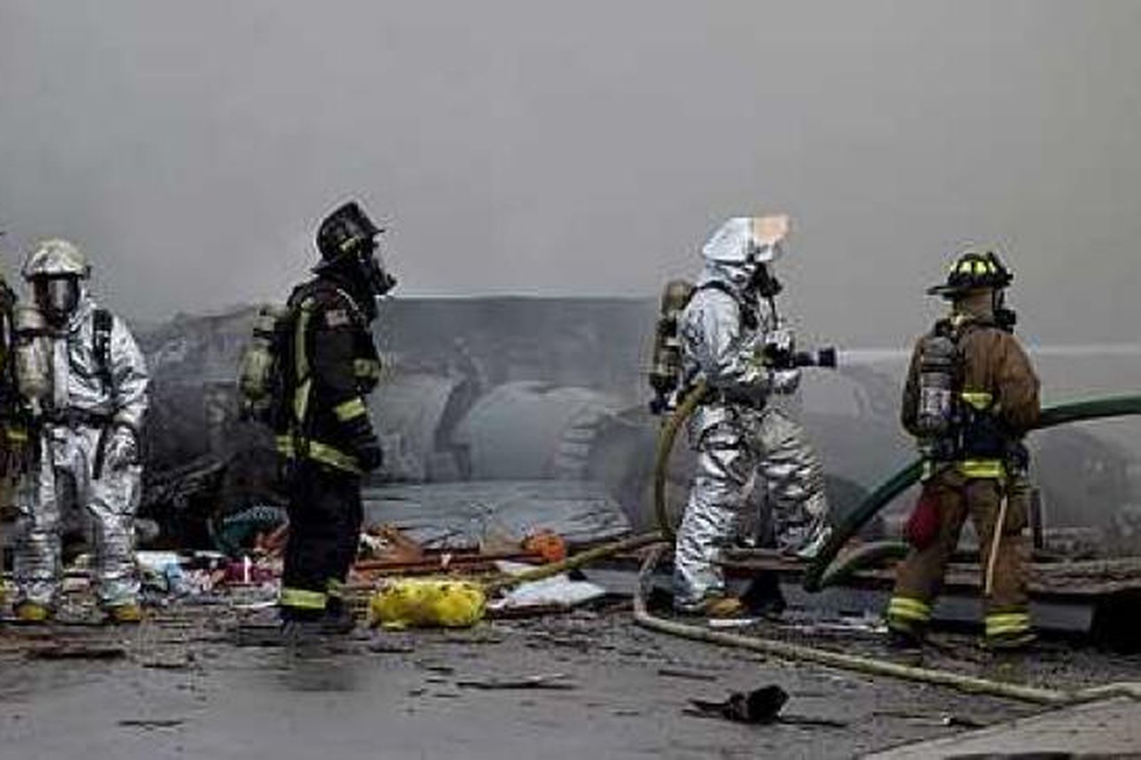 Slökkviliðsmenn við flak flugvélarinnar.