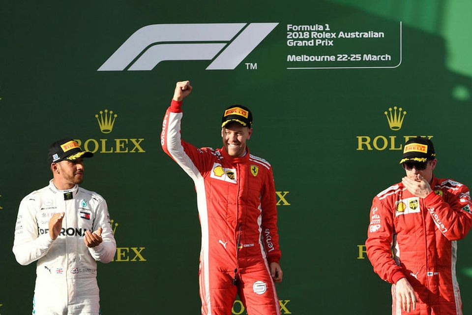 Fyrstu þrír á palli, Sebastian Vettel fagnar sigri með Lewis Hamilton sér til hægri handar …