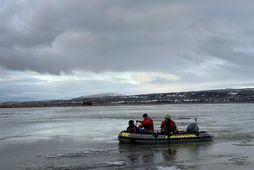 Björgunarsveitarmenn sigla yfir tún til að koma erlendum ferðamanni til bjargar.