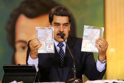 Nicolas Maduro með vegabréf mannanna.
