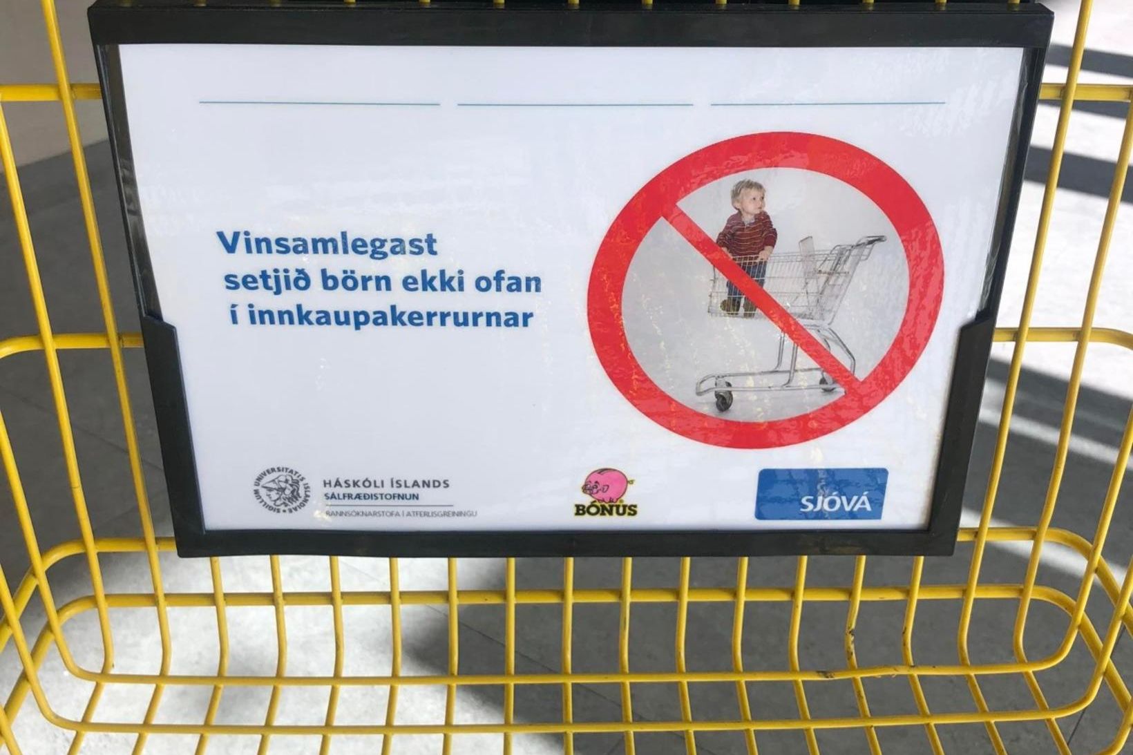 Viðvörunarspjald í innkaupakerru í matvöruverslun.