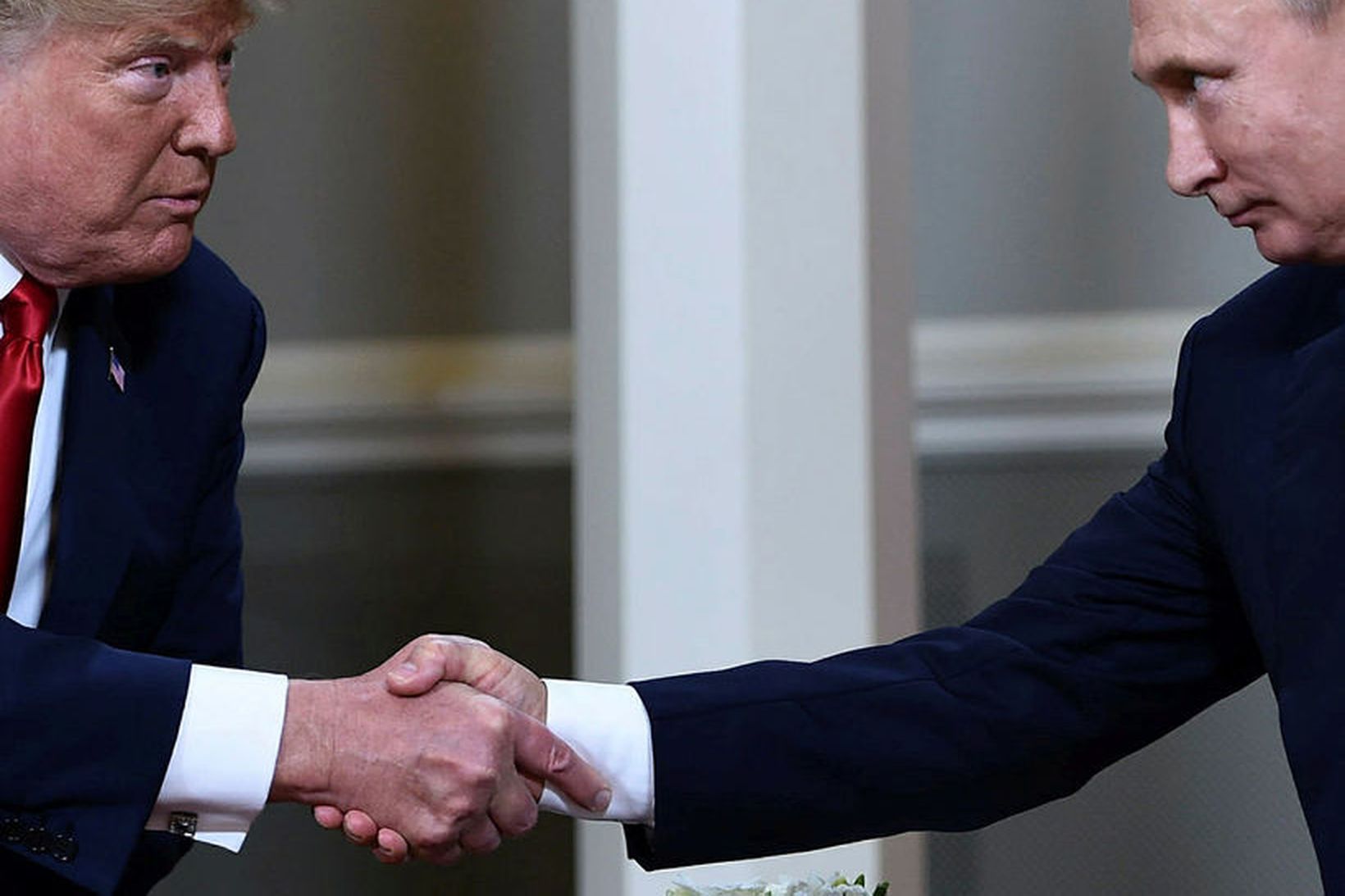 Donald Trump Bandaríkjaforseti og Vladimír Pútín Rússlandsforseti takast í hendur …