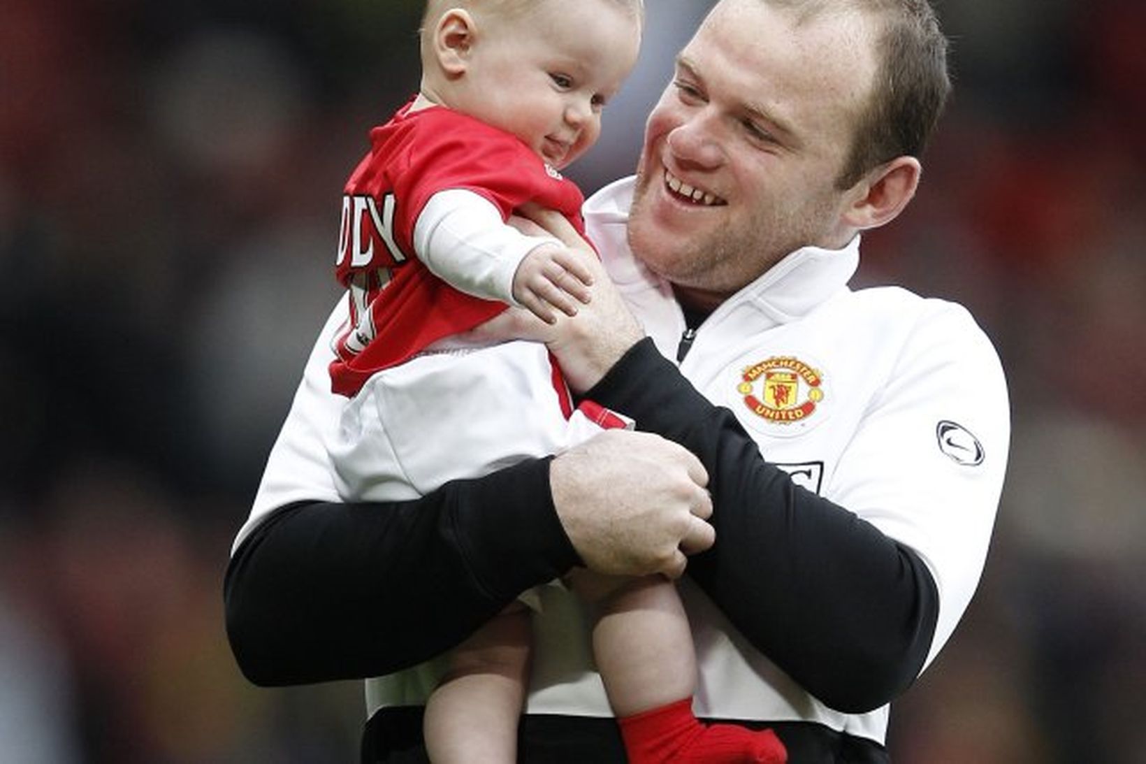 Wayne Rooney heldur á syni sínum, Kai Rooney, eftir leikinn …