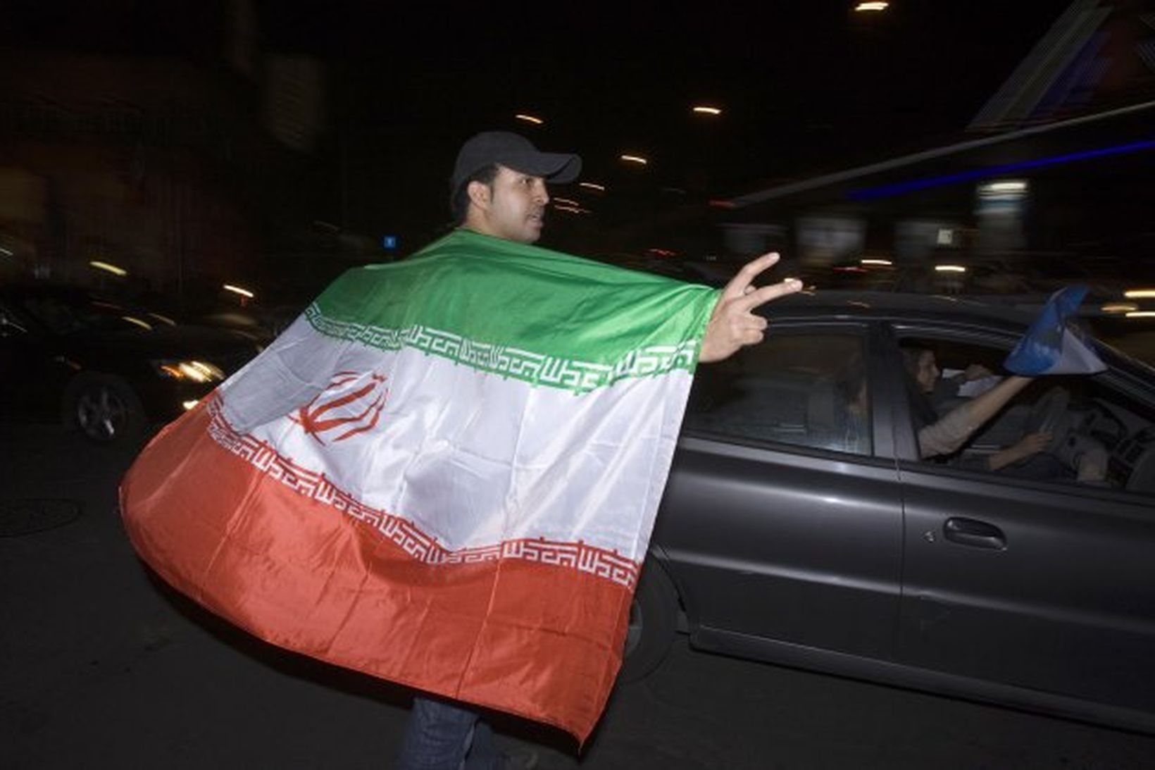 Stuðningsmaður Ahmadinejad með íranska fánann á götum Teheran.