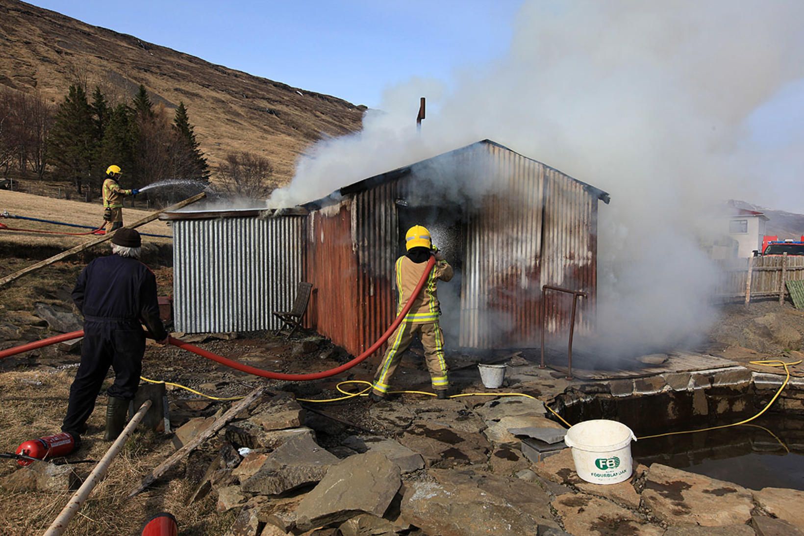 Slökkviliðsmenn að störfum við að slökkva eldinn í baðhúsinu í …