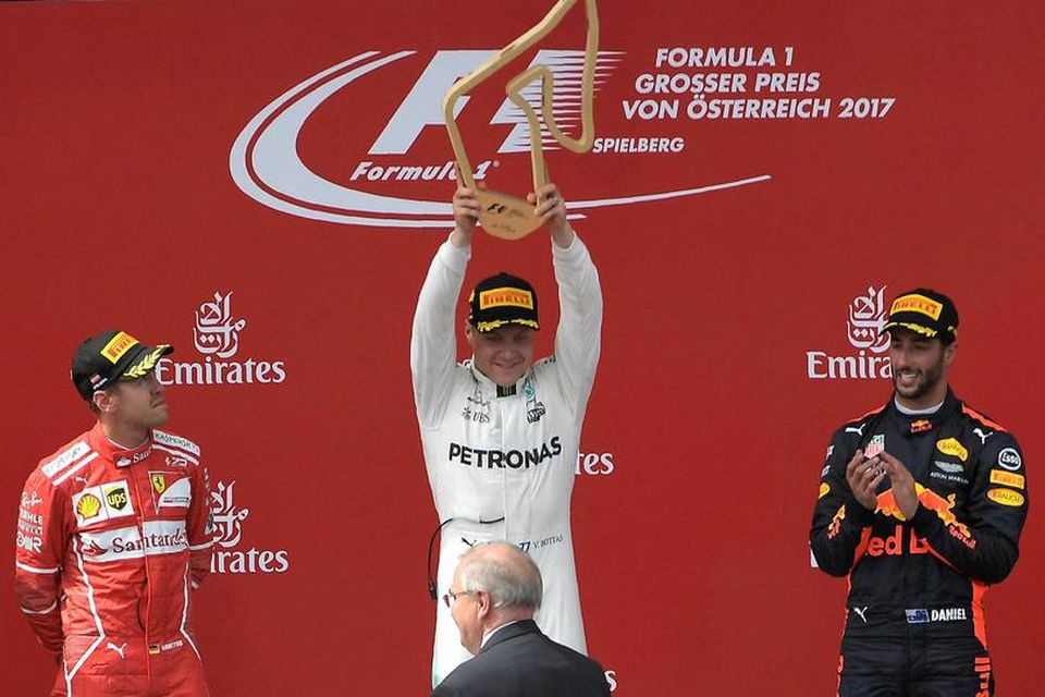 Sebastian Vettel (t.v.) og Daniel Ricciardo (t.h.) samgleðjast Valtteri Bottas á verðlaunapallinum í Spielberg í …