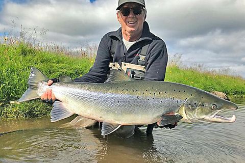 Eric Clapton with his giant salmon on Friday.  .