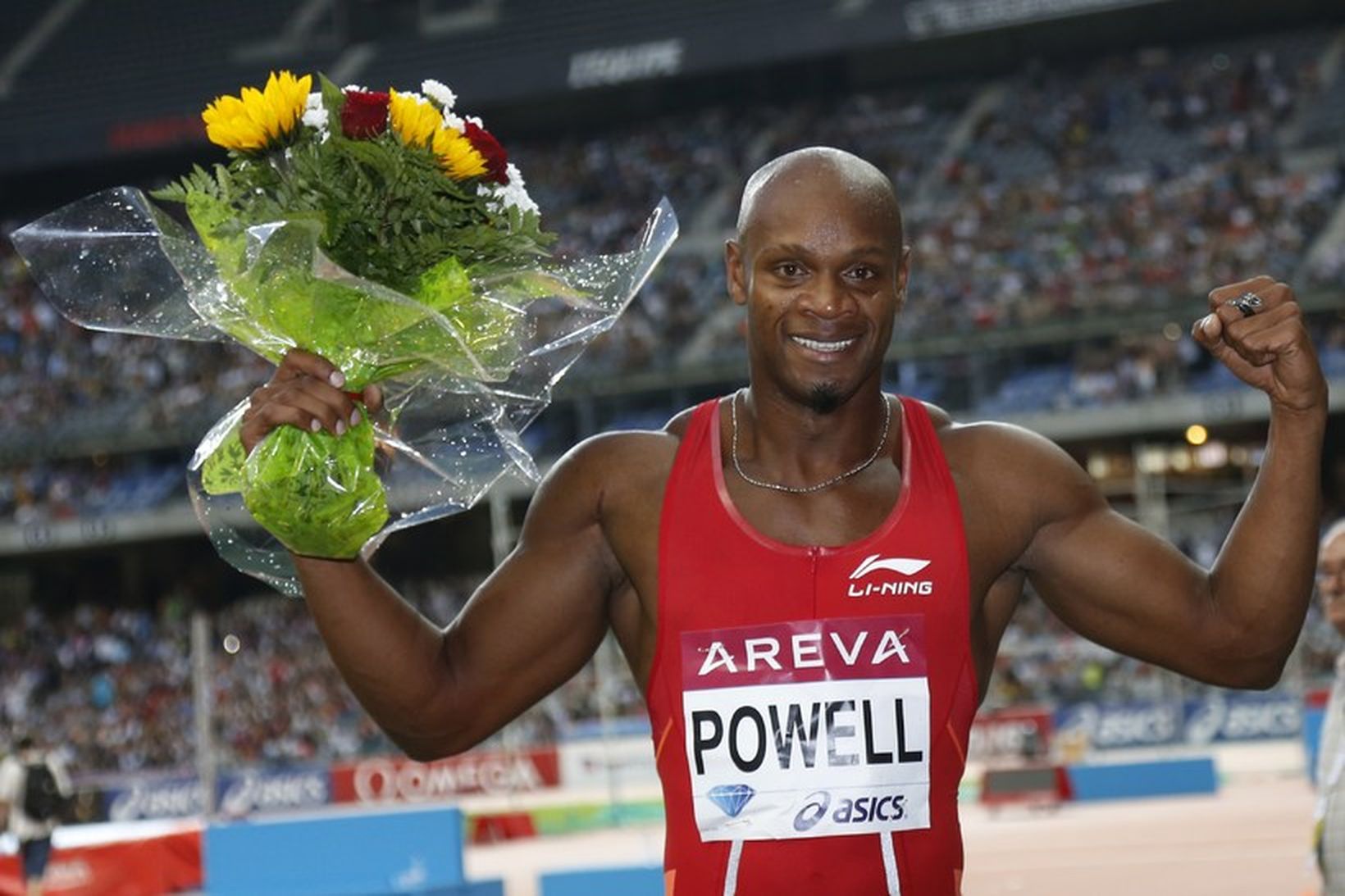 Asafa Powell með blómvöndinn eftir sigurinn í kvöld.