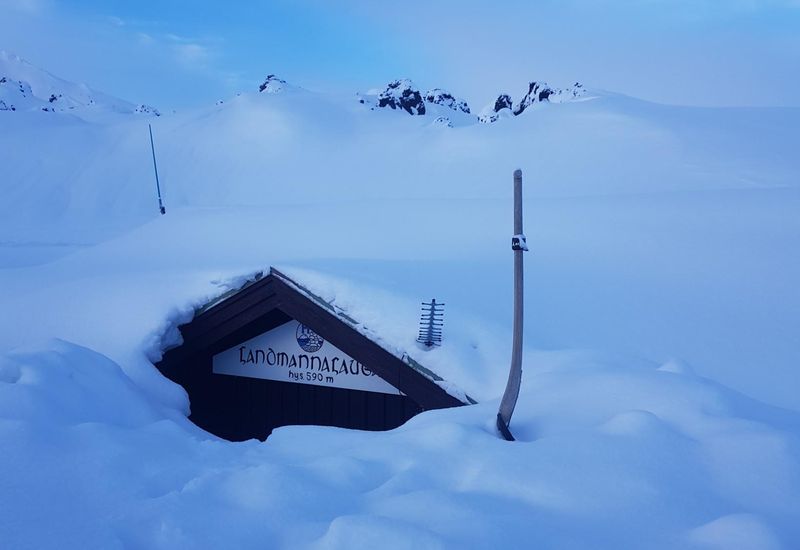 The FÍ chalet, buried in snow.