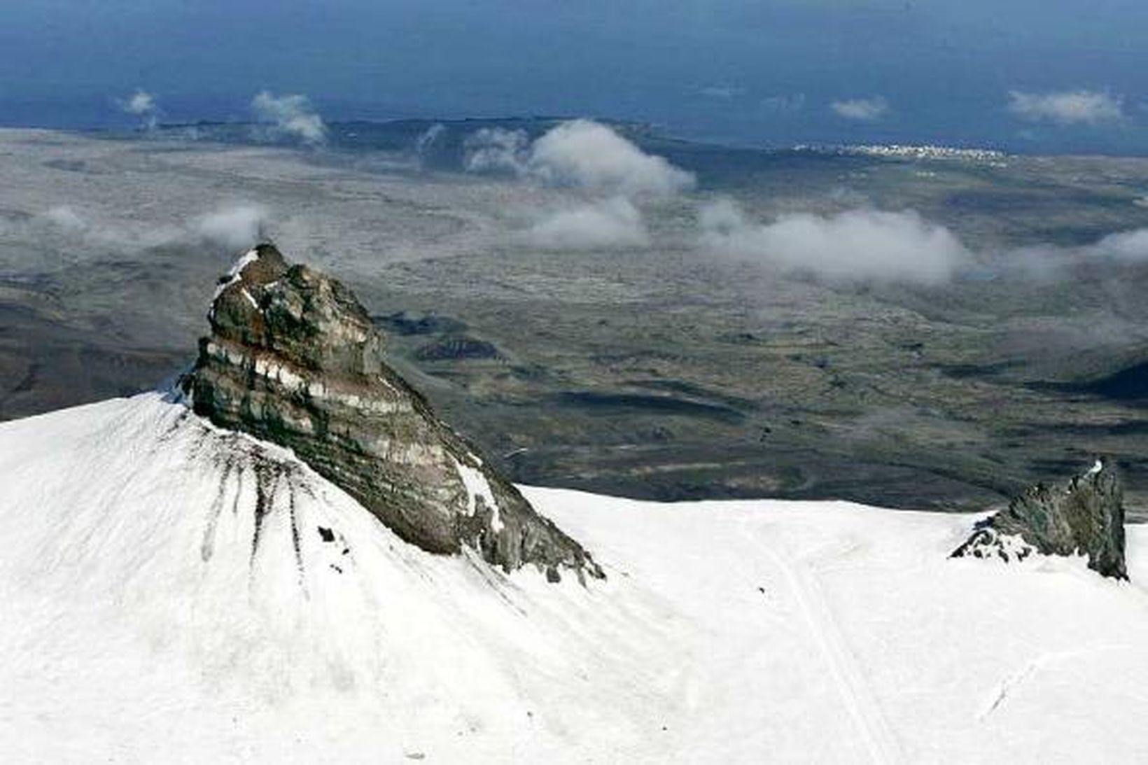 Íslensk náttúra er engri lík. Hér sést tindur Snæfellsjökuls teygja …