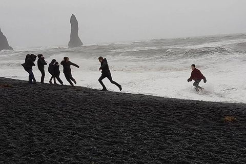 Tourists running into the waves and laughing at Iceland's most dangerous beach.