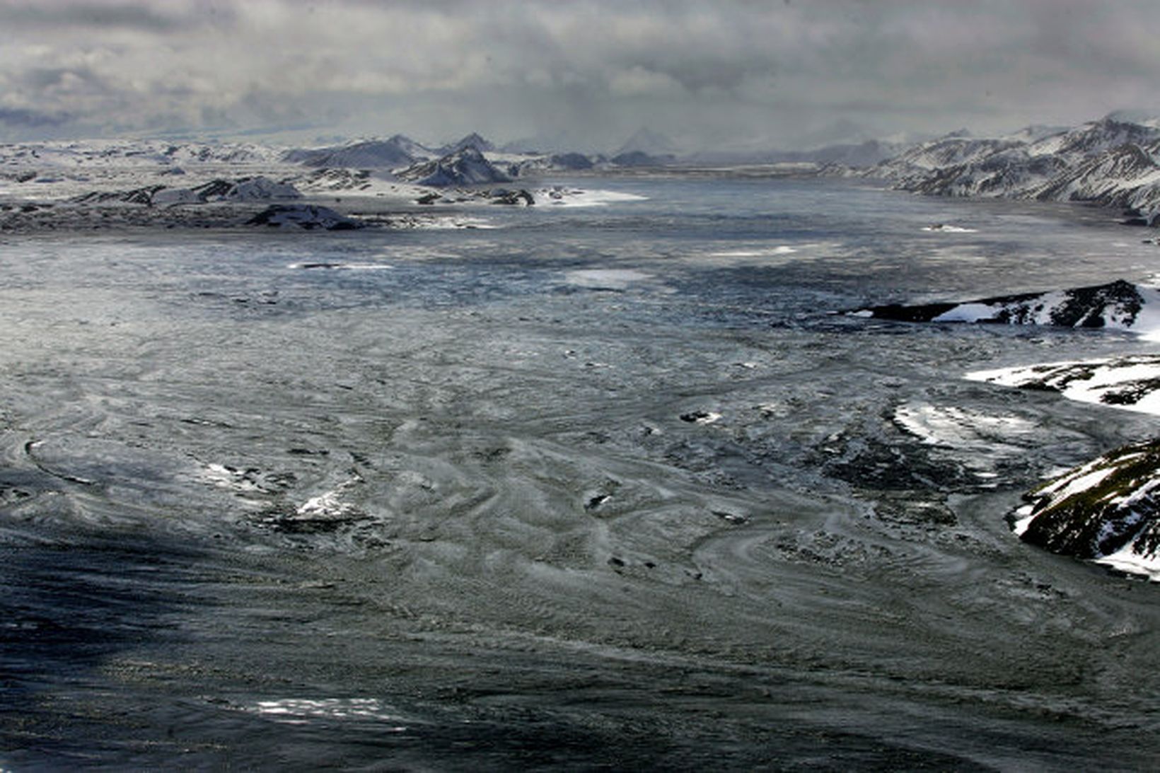 Litið yfir beljandi og leirlitaða Skaftána frá jökulsporðinum, þegar hljóp …