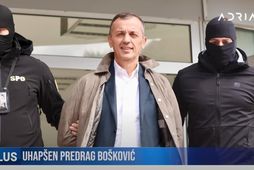 Predrag Boskovic, fyrir miðju, handsamaður af laganna vörðum.