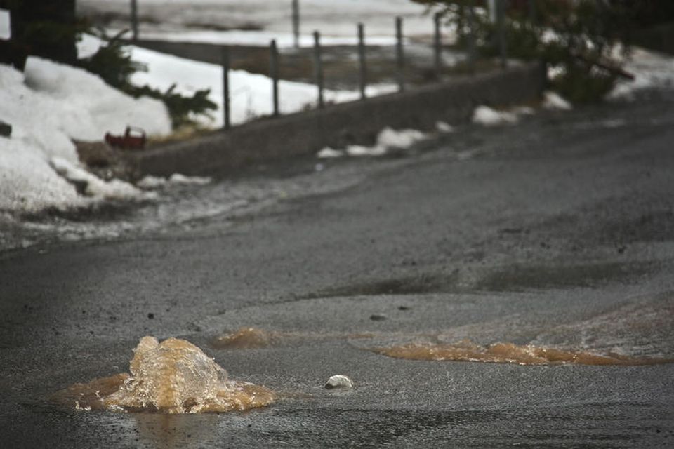 Vatn streymir upp úr götum og holræsakerfum á Ísafirði.