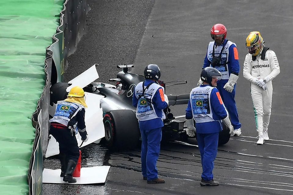 Lewis Hamilton skoðar bíl sinn eftir skellinn við öryggisveggnum í Sao Paulo.