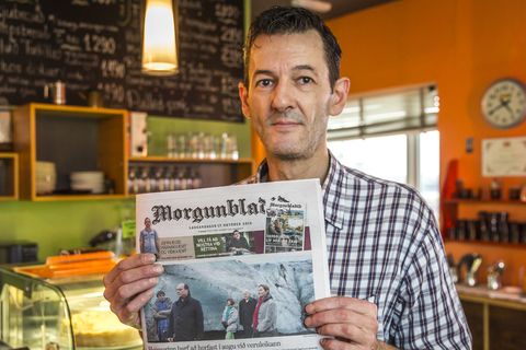 Manuel Vincent Colsy, holding a copy of Saturday's edition of Morgunblaðið. The front page features a photograph of himself, and a photograph of François Hollande, President of France. "I'm sending this to my mother," he says.
