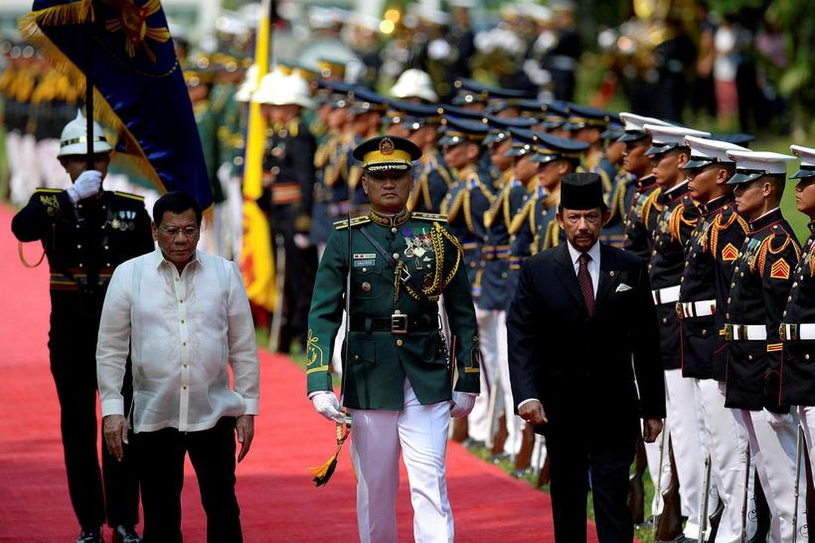 Rodrigo Duterte (t.v.) gengur ásamt soldáninum í Brunei framhjá heiðursverði …
