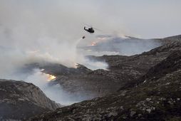 Þyrla varpar sjó á eldana á Frøya.