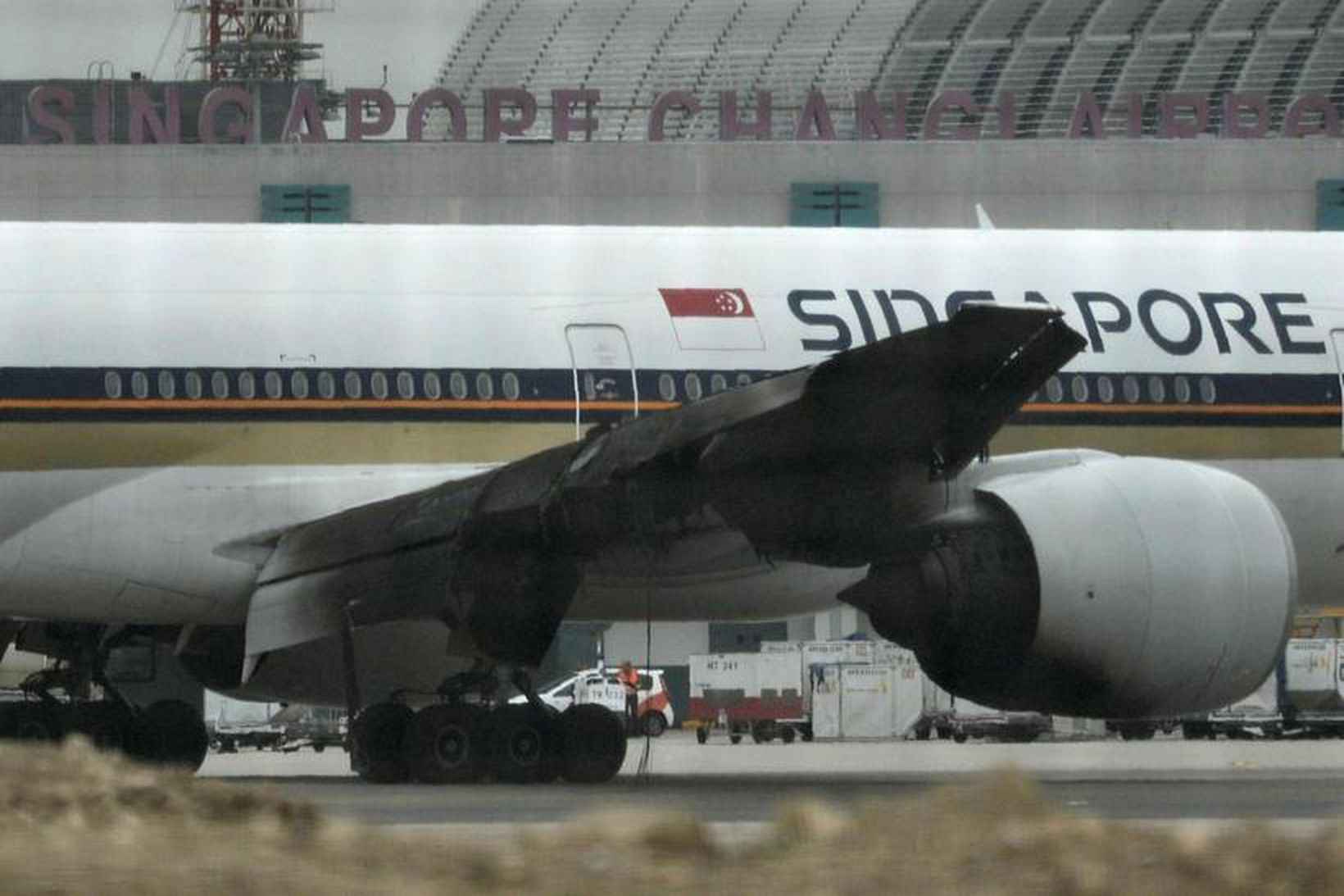 Sviðinn vængur og hreyfill Boeing 777-300ER Singapore Airlines á flugbrautinni …